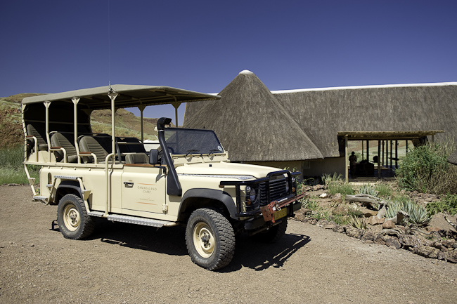 Game drive vehicle in front of camp